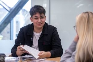 apprentice in a classroom talking to a resident about courses available