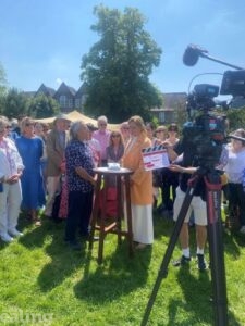 BBC camera filming an episode of Antiques Roadshow outside Pitzhanger Manor with crowds standing round watching a member of the public talk to one of the experts