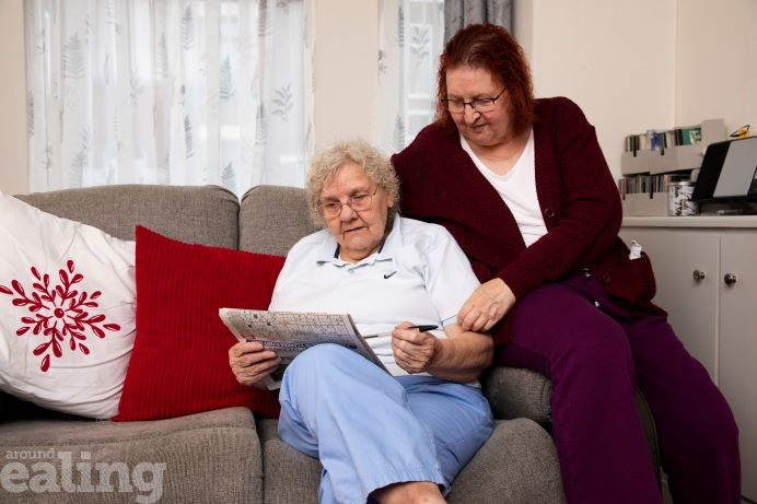 Older woman sitting on the sofa with younger woman.