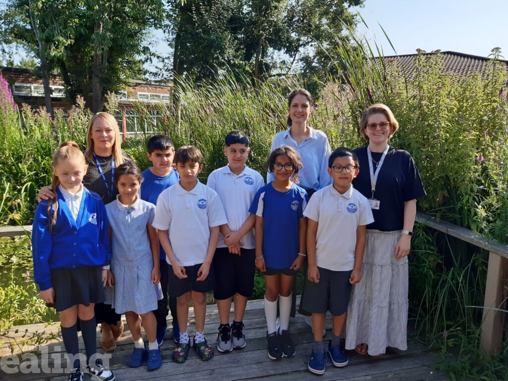 Cllr Blerina Hashani, cabinet member for thriving communities is joined by a group of school children, headteacher Ms Crosdale and school governor for community cohesion at Brentside School garden