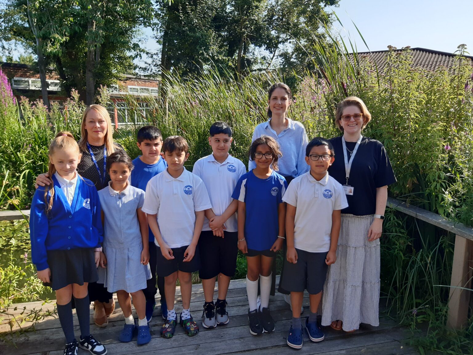 Cllr Blerina Hashani, cabinet member for thriving communities is joined by a group of school children, headteacher Ms Crosdale and school governor for community cohesion at Brentside School garden