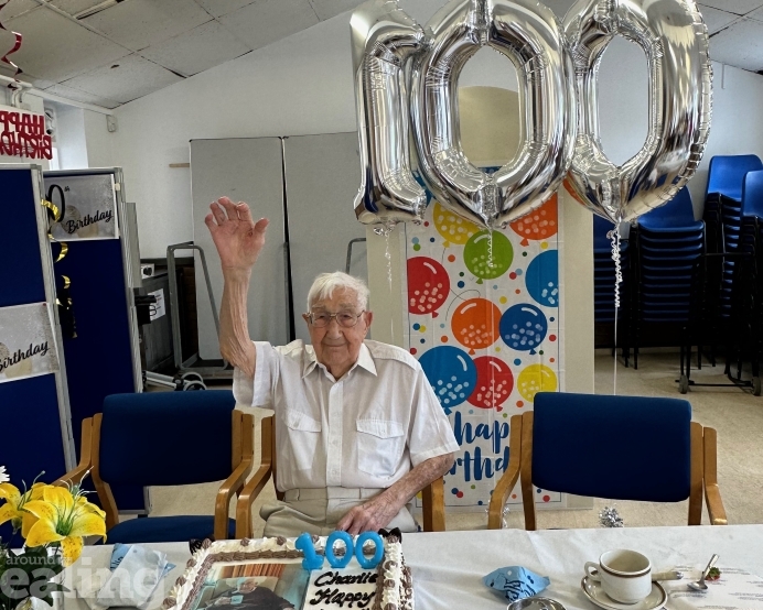 Centenarian Charlie with birthday cake and balloons