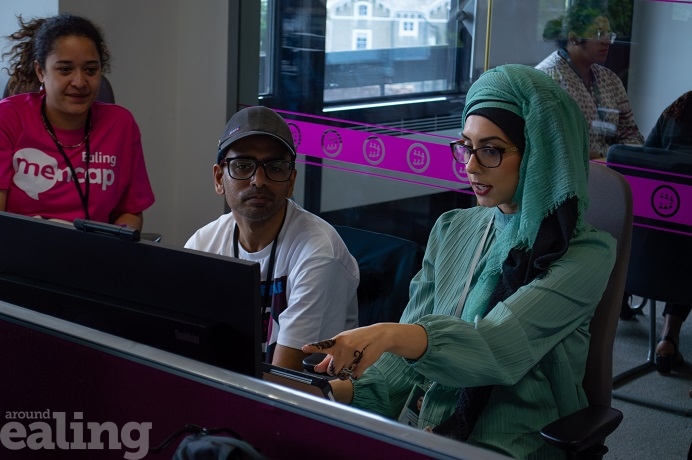 2 adult women and an adult male sitting and looking at a computer screen