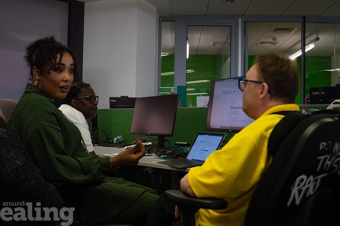 3 adults sitting at a computer talking