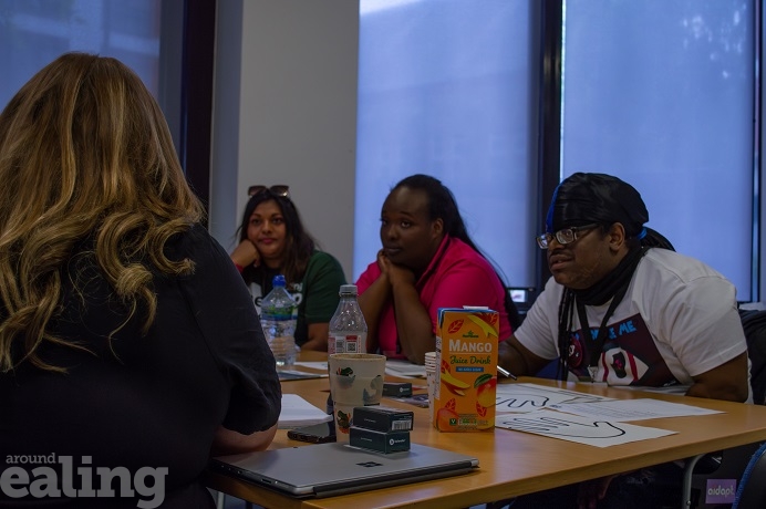 4 adults sitting at a table talking and listening