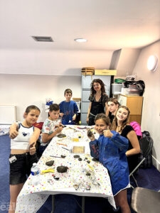 Ukrainian refugee children working on art at a table