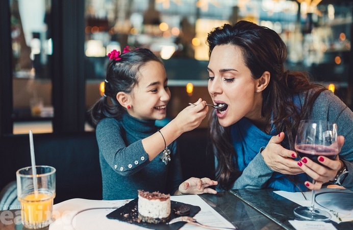 A mum and her child eating in a restaurant