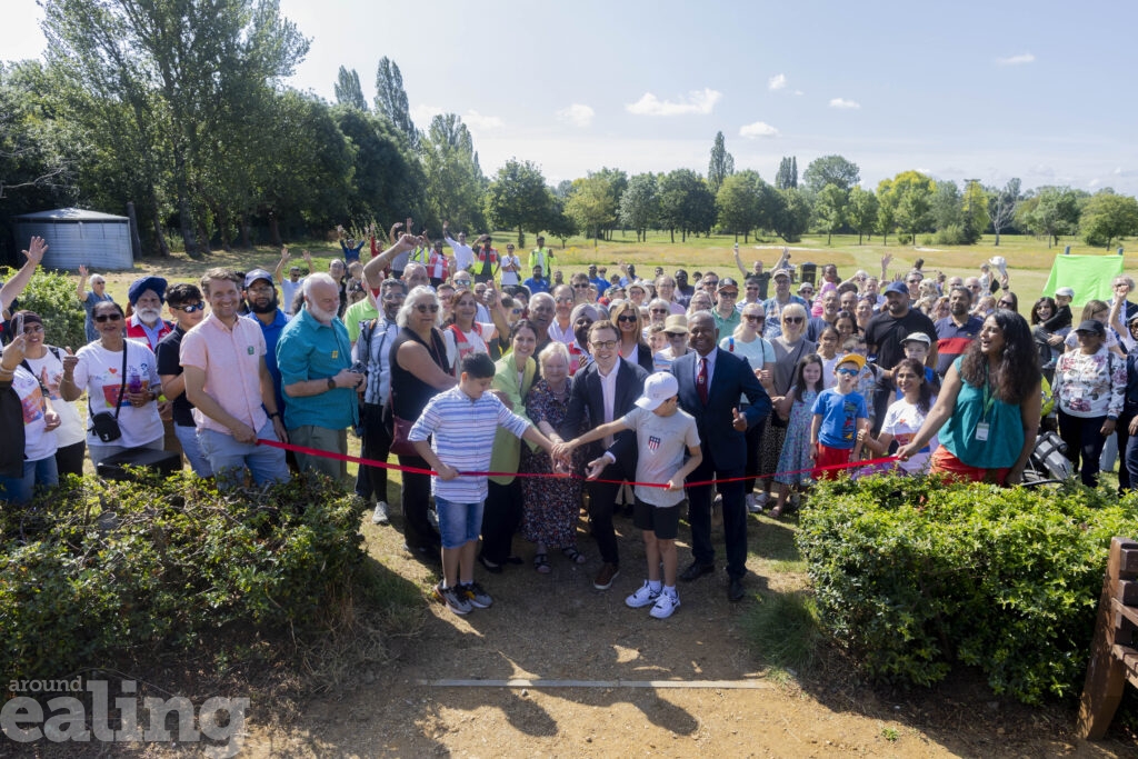 A large group of people at a ribbon cutting ceremony at Pear Tree Park