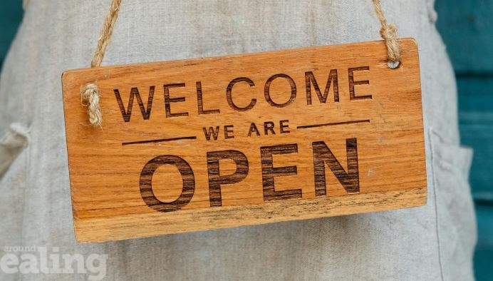 Economy: Wooden sign that says Welcome, we are open