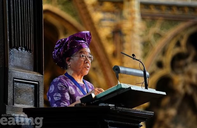 A woman speaks at a podium with a microphone, addressing an audience seated before her. Dame Elizabeth passionate advocate for improving healthcare for London’s Black community