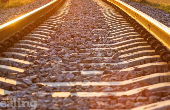 A close-up view of train tracks illuminated by sunlight. HS2 and Ealing Council are in talks to support businesses and residents.