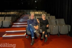 man and woman sitting and smiling in cinema theatre