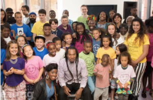 Thee late Benjamin Zephaniah surrounded by lots of children