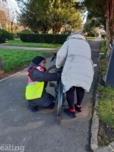 Huda kneeling down to help another rider with their bike.