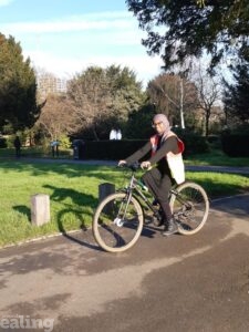 Huda on her bike in a park.