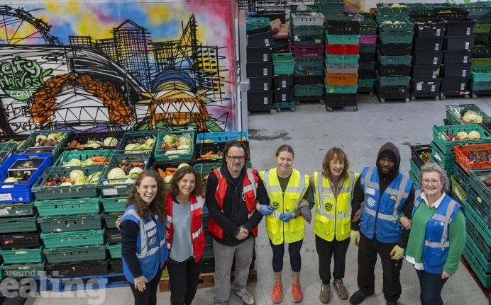 group of people in warehouse with crates stacked with food