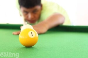 close up of teen boy playing pool