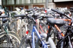 A number of bikes locked up together in a city centre