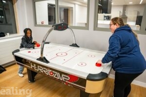 Young people playing air hockey at Southall YAC