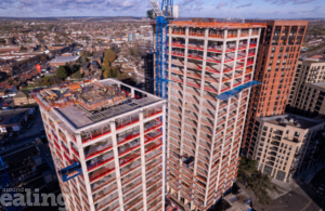 Two tall building blocks under construction at Merrick Place, featuring cranes and scaffolding against a clear sky. 2