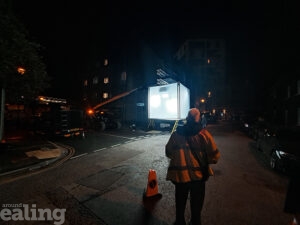 A lit-up cube in a residential street at night