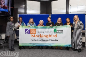 Group of people holding up a banner saying Mockingbird fostering support scheme