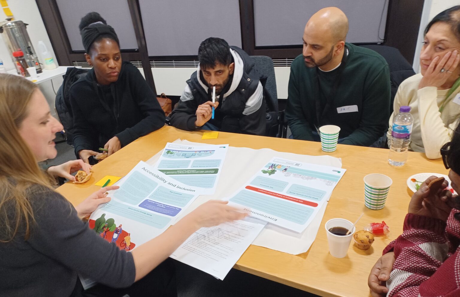 A group of residents discussing transport in Ealing around a table.