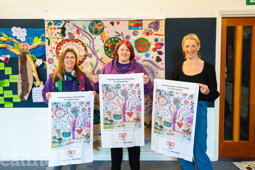 3 women standing holding artwork