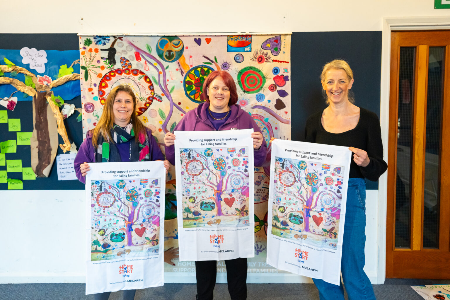 3 women standing holding artwork