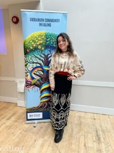 woman standing smiling in front of decorative banner