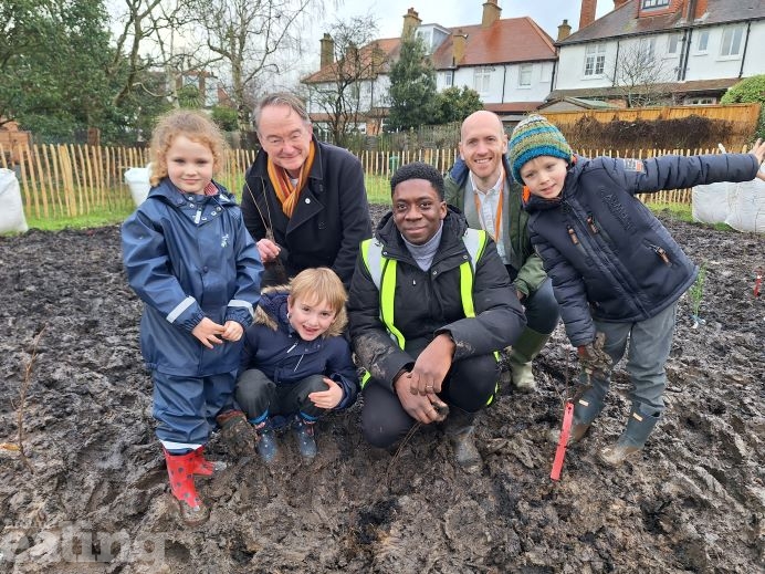 Council members, school staff and pupils planting tree saplings